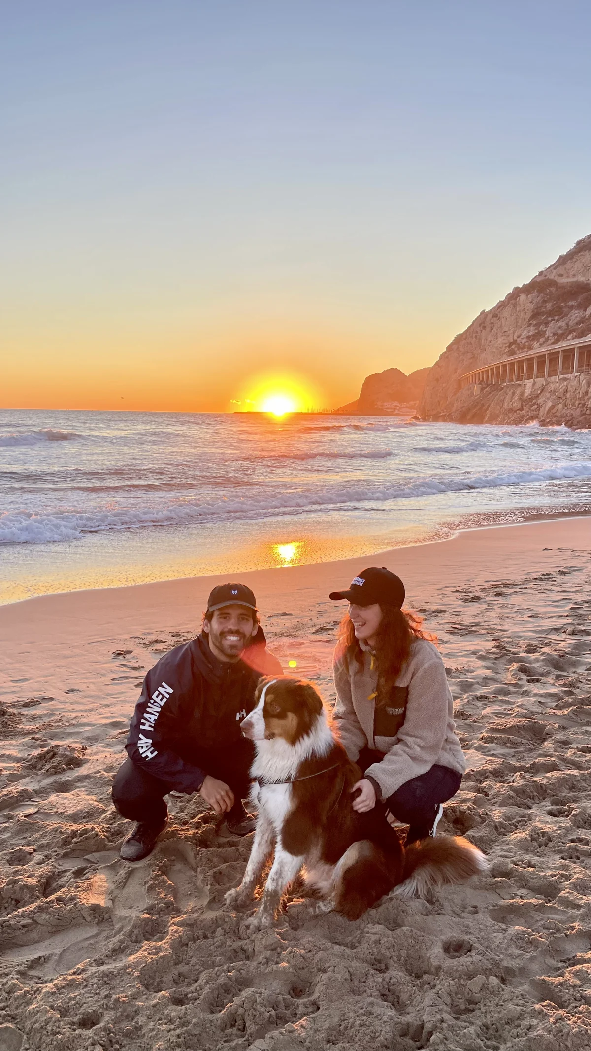Mery and Edi with their dog on the beach at sunset